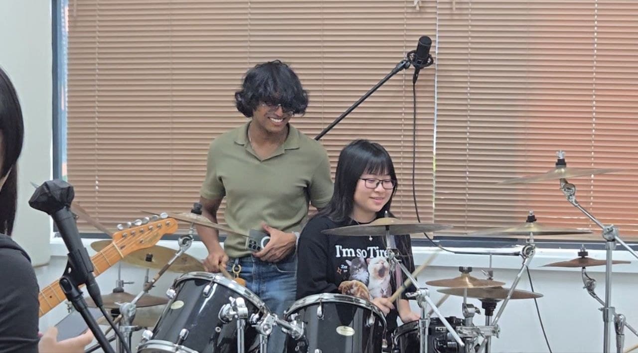 A drum instructor guiding a student in the studio